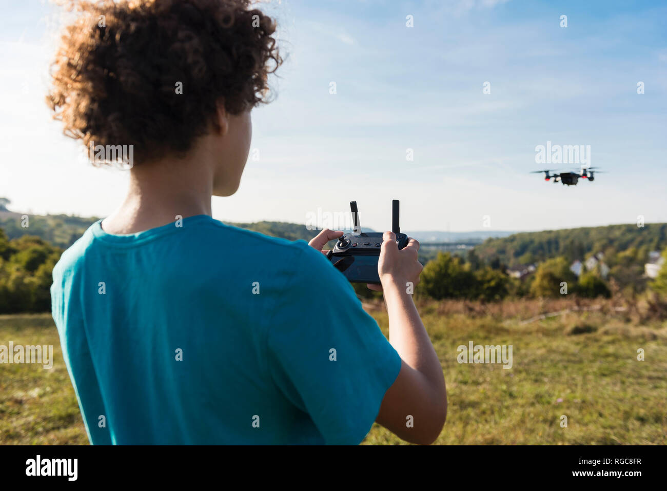 Ragazzo la navigazione di un flying drone all'aperto Foto Stock
