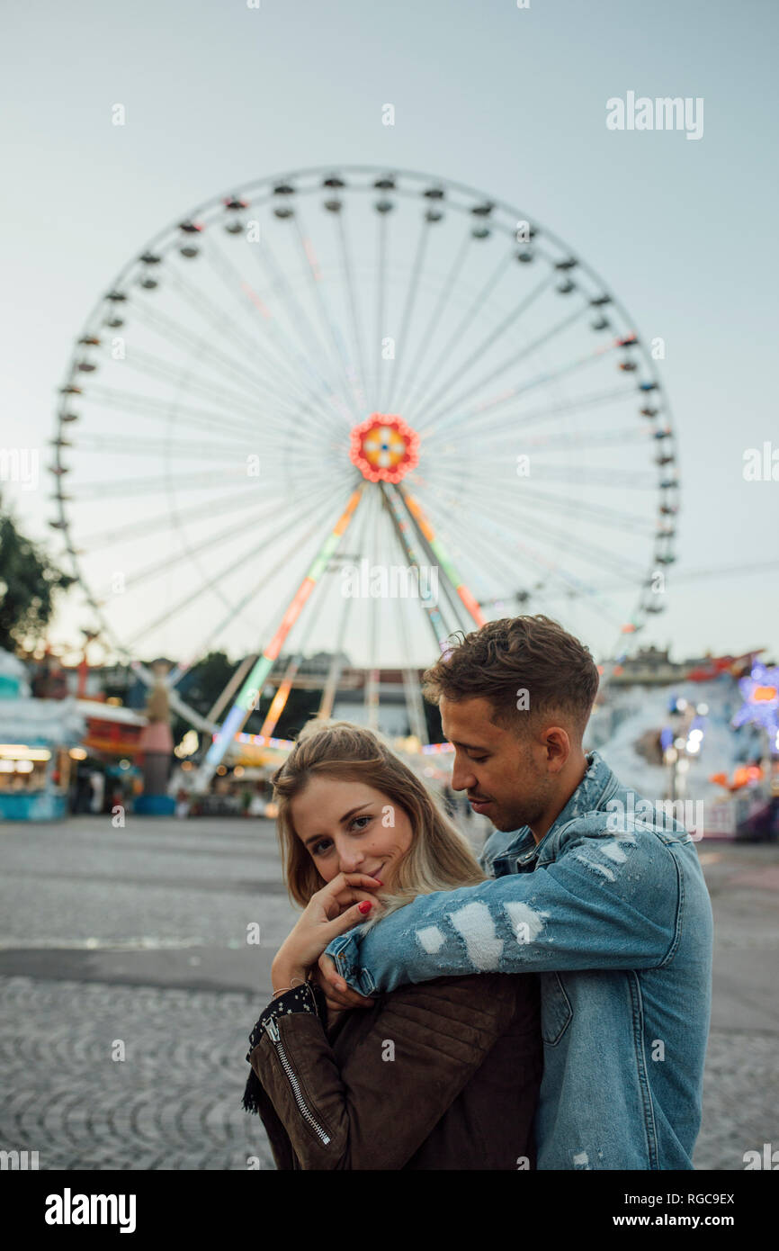 Coppia giovane in amore, abbracciando in un luna park Foto Stock