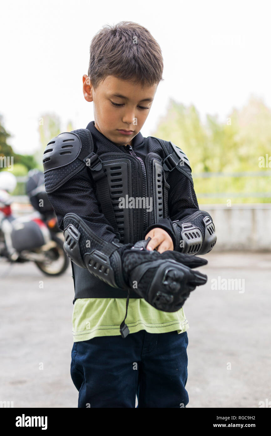 Ragazzo mettendo su abbigliamento protettivo per la preparazione di un  viaggio in moto Foto stock - Alamy