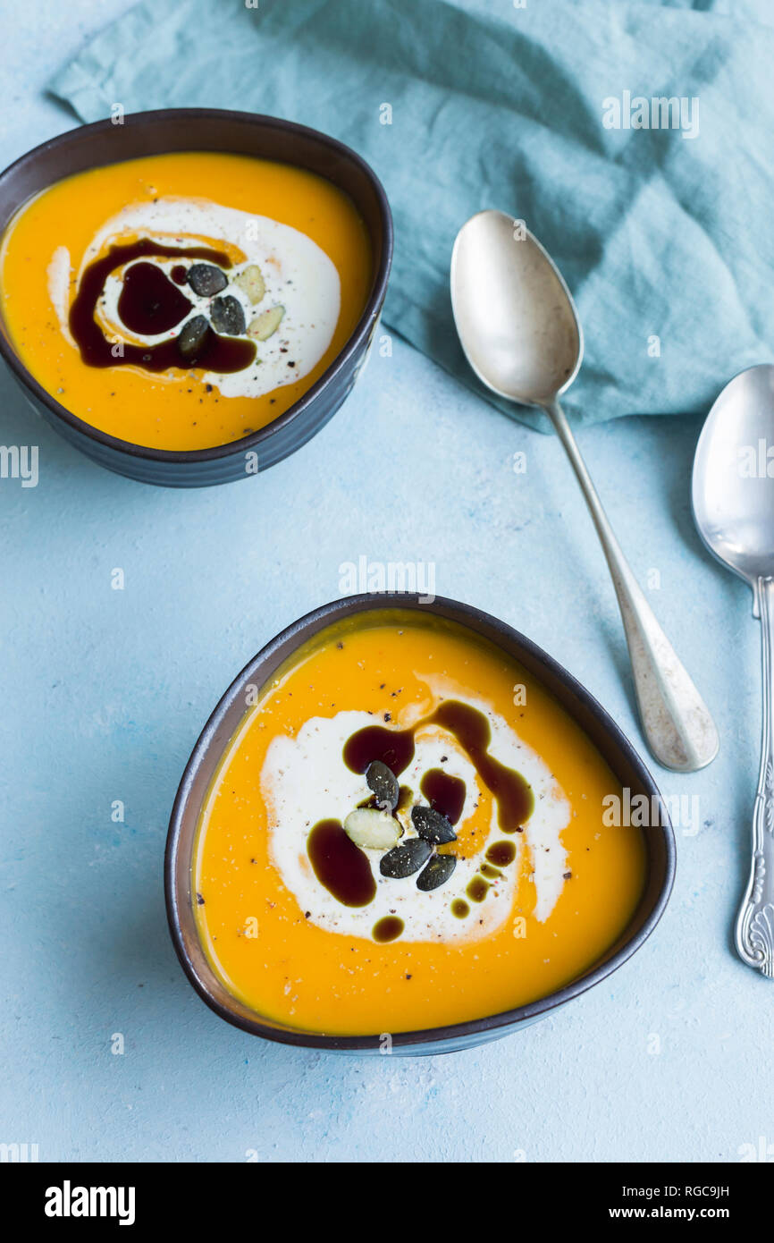 Due ciotole in casa di Hokkaido zuppa di zucca farcita con crema di zucca, semi e olio di semi di zucca Foto Stock