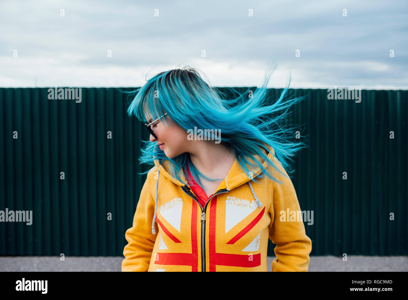 Giovane donna con soffiaggio tinti di blu capelli Foto Stock