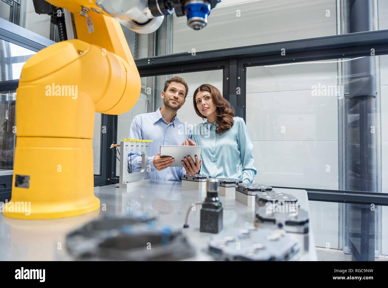 I colleghi di high tech azienda il controllo di robot industriali, con tavoletta digitale Foto Stock