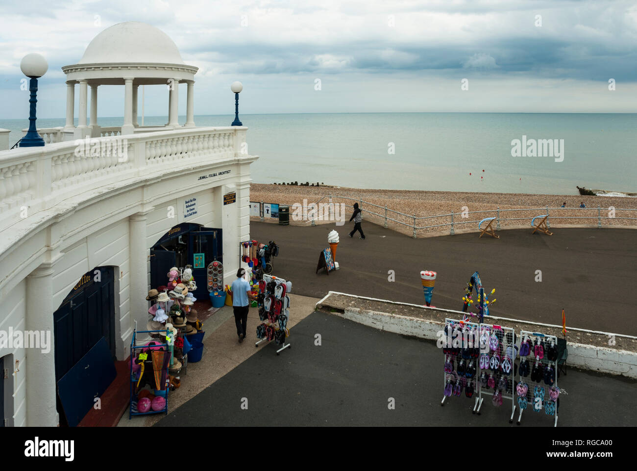 Una tipica località balneare inglese shop on Bexhill promenade con la spiaggia di ciottoli e mare in background; a seguito di pioggia. Foto Stock