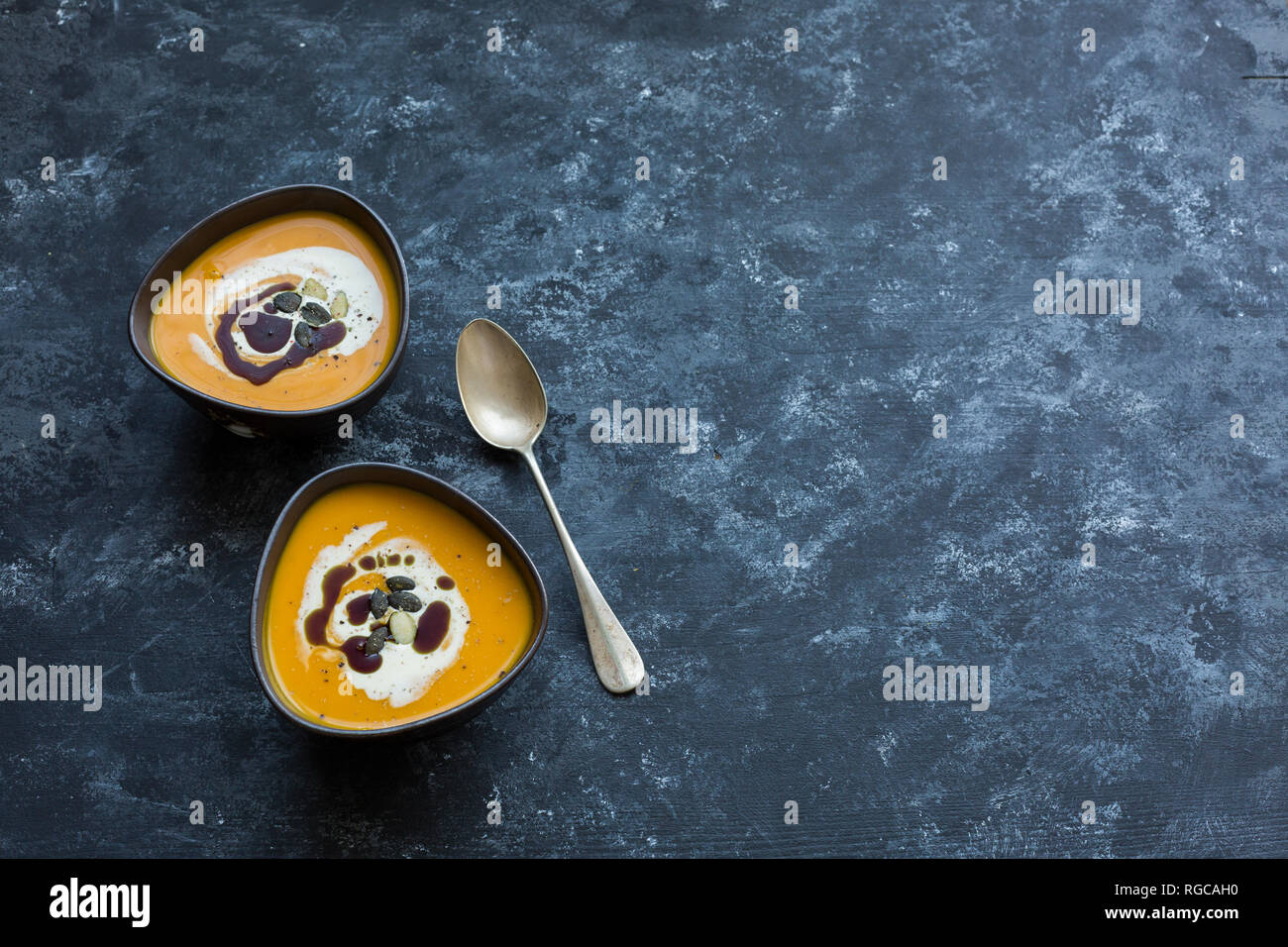 Due ciotole in casa di Hokkaido zuppa di zucca farcita con crema di zucca, semi e olio di semi di zucca Foto Stock