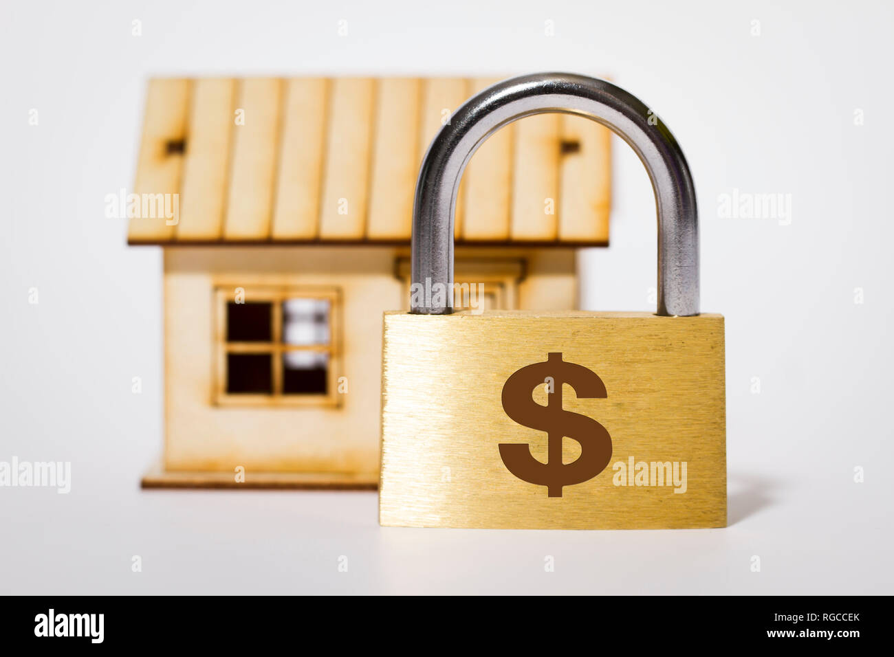 Piccola casa con serratura, protezione di sicurezza degli asset, segno del dollaro Foto Stock