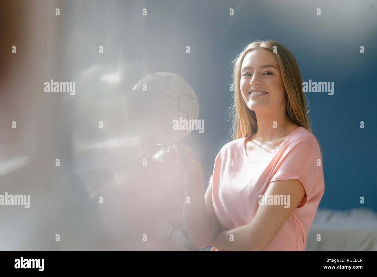 Ritratto di sorridente giovane donna con globo Foto Stock