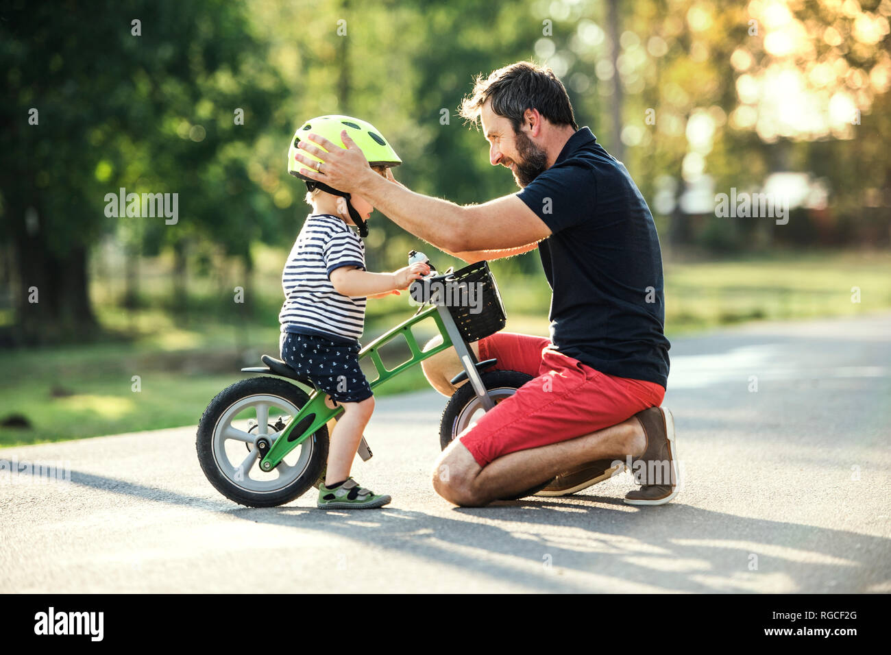 Padre il supporto piccolo figlio in bici Foto Stock