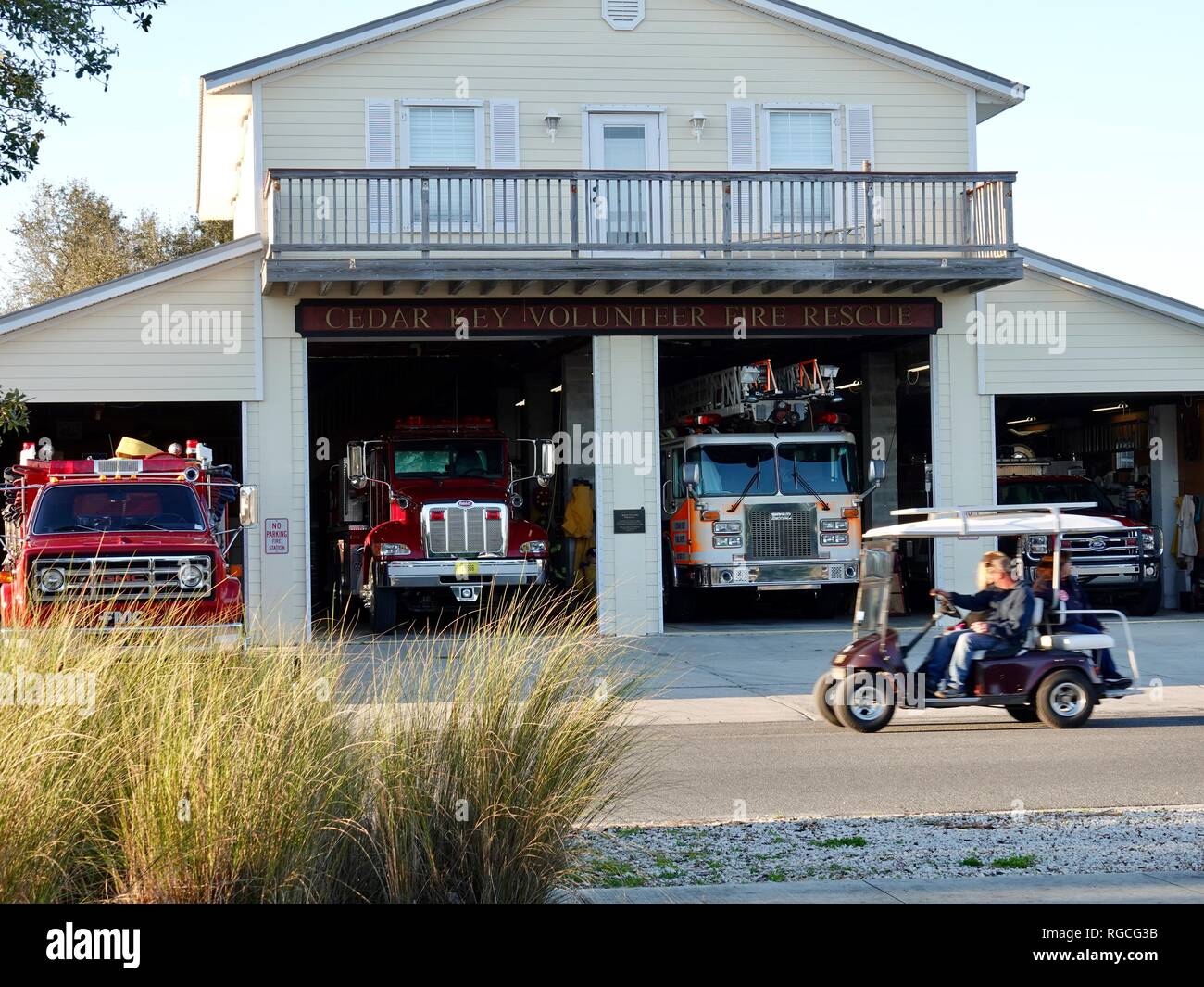 Matura in golf cart guidando attraverso il Cedar Key Fuoco volontari Dipartimento soccorso, Florida, Stati Uniti d'America. Foto Stock