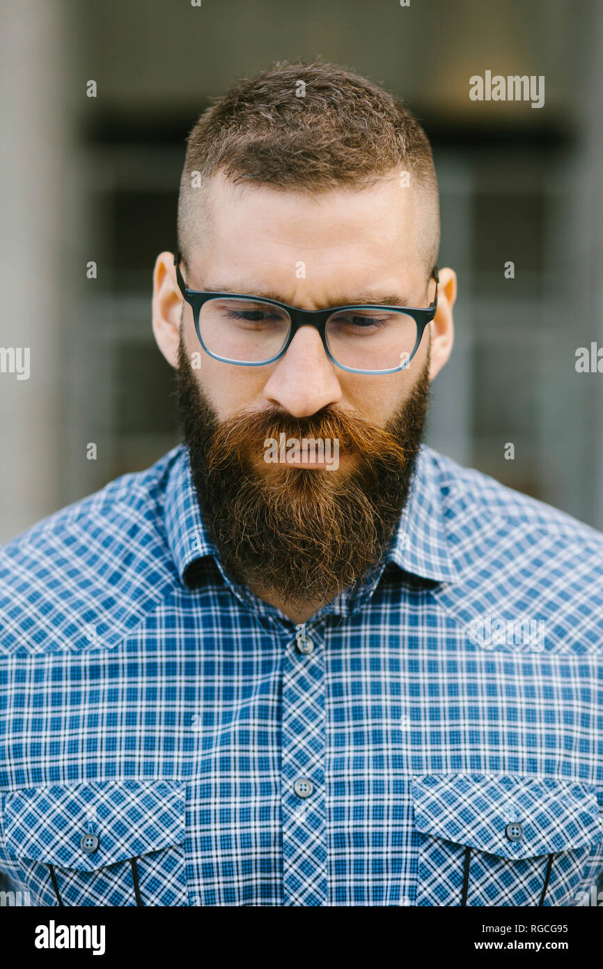Ritratto di barbuto hipster imprenditore indossando occhiali e plaid shirt Foto Stock
