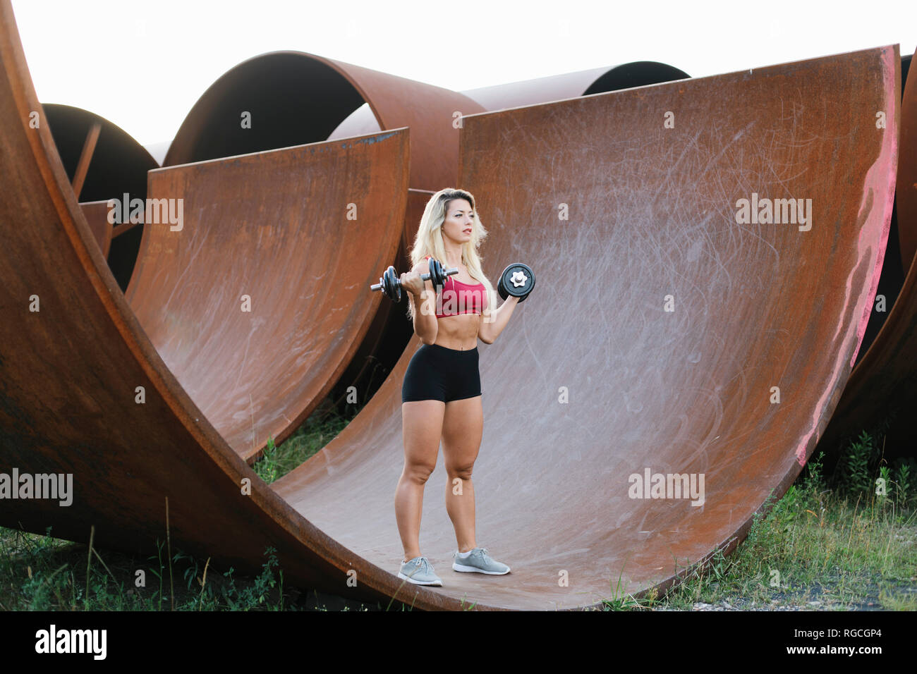 Athletic donna facendo peso allenamento presso il sito industriale Foto Stock