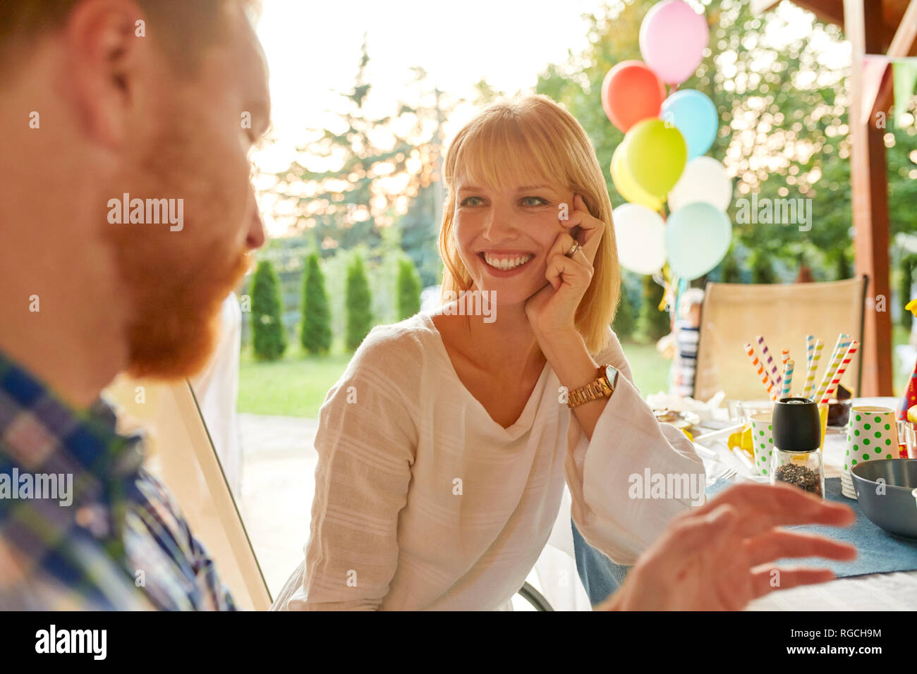 Donna sorridente guardando un uomo su un party in giardino Foto Stock