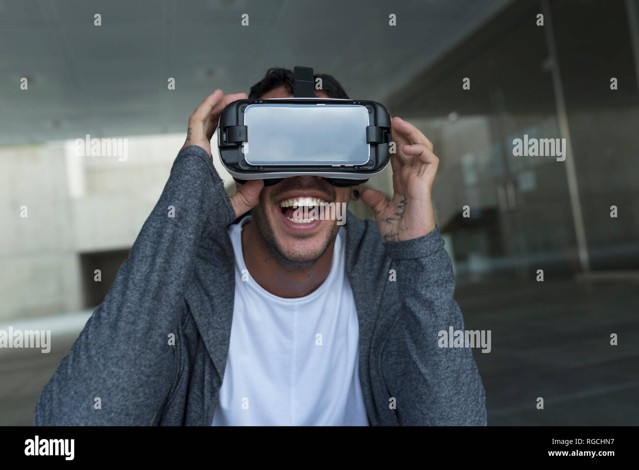 Eccitato giovane uomo che indossa occhiali per realtà virtuale Foto Stock