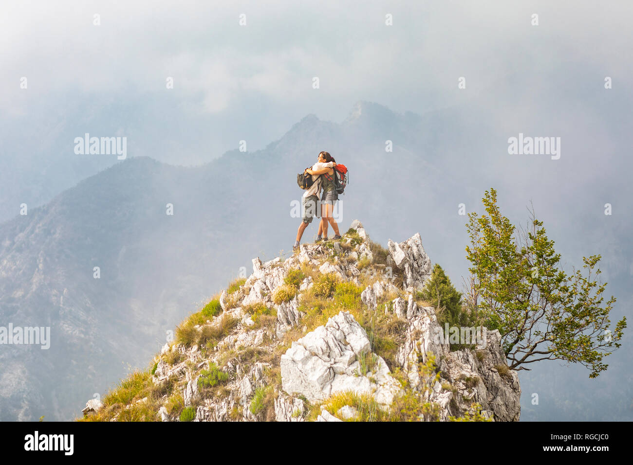 L'Italia, Massa, coppia felice costeggiata sulla sommità di un picco nelle Alpi Apuane montagne Foto Stock