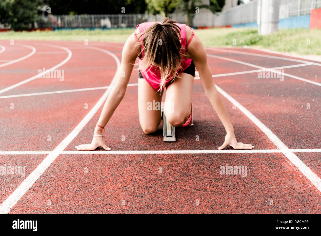 Teenage Runner in posizione iniziale sulla pista Foto Stock