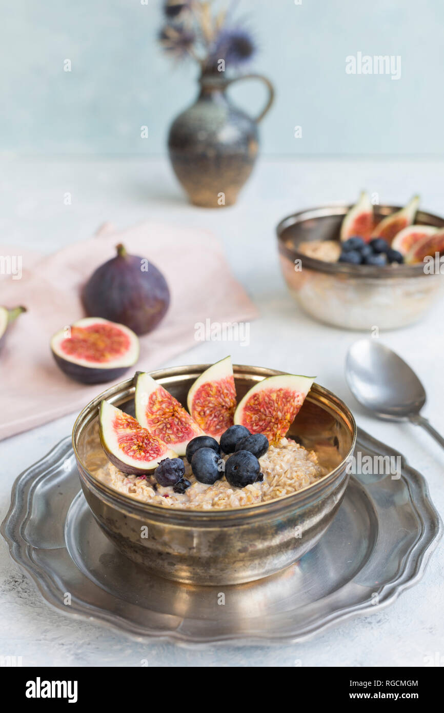 Ciotola di porridge con fette di fichi, mirtilli e frutti di bosco essiccati Foto Stock