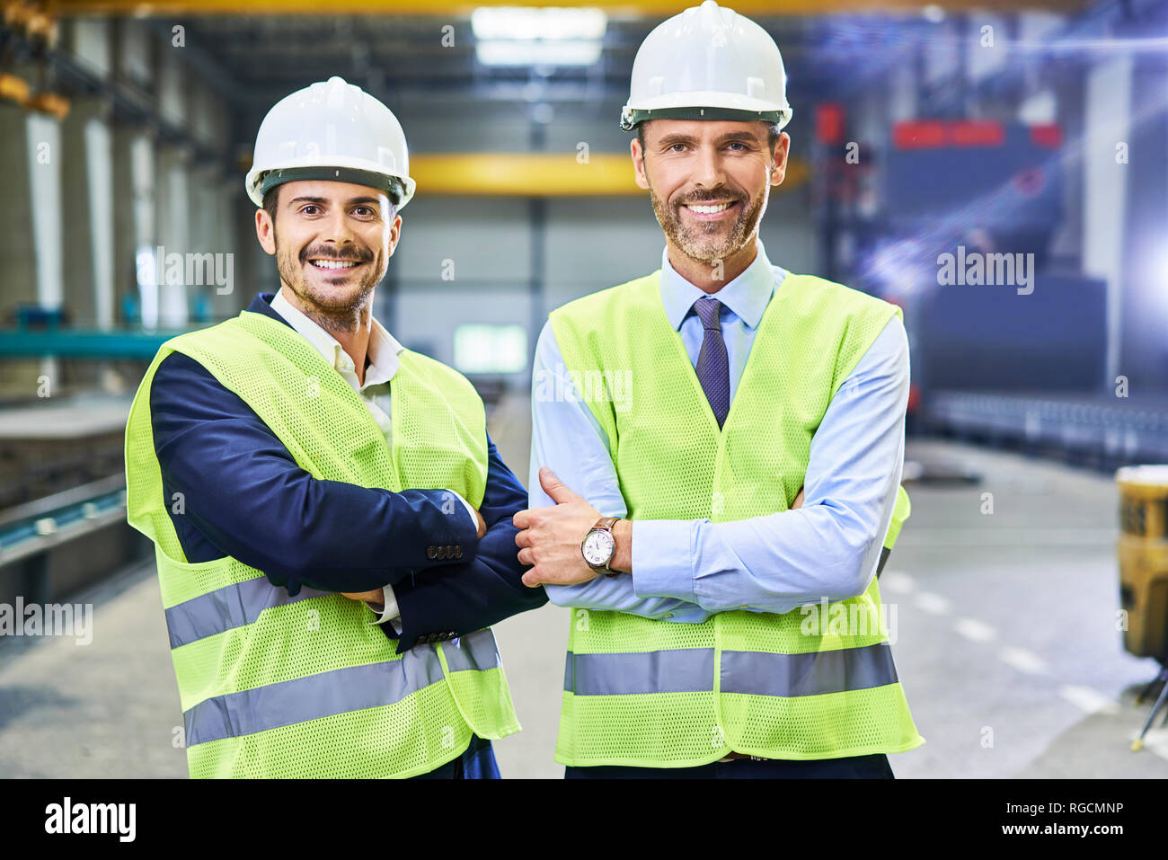 Ritratto di due gestori sorridente indossando indumenti da lavoro protettiva in fabbrica Foto Stock