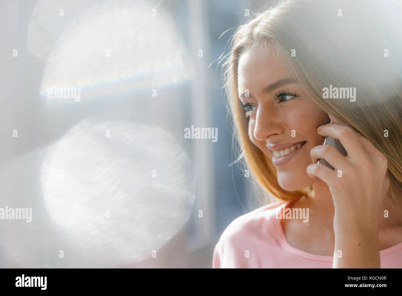 Ritratto di sorridente giovane donna al telefono Foto Stock