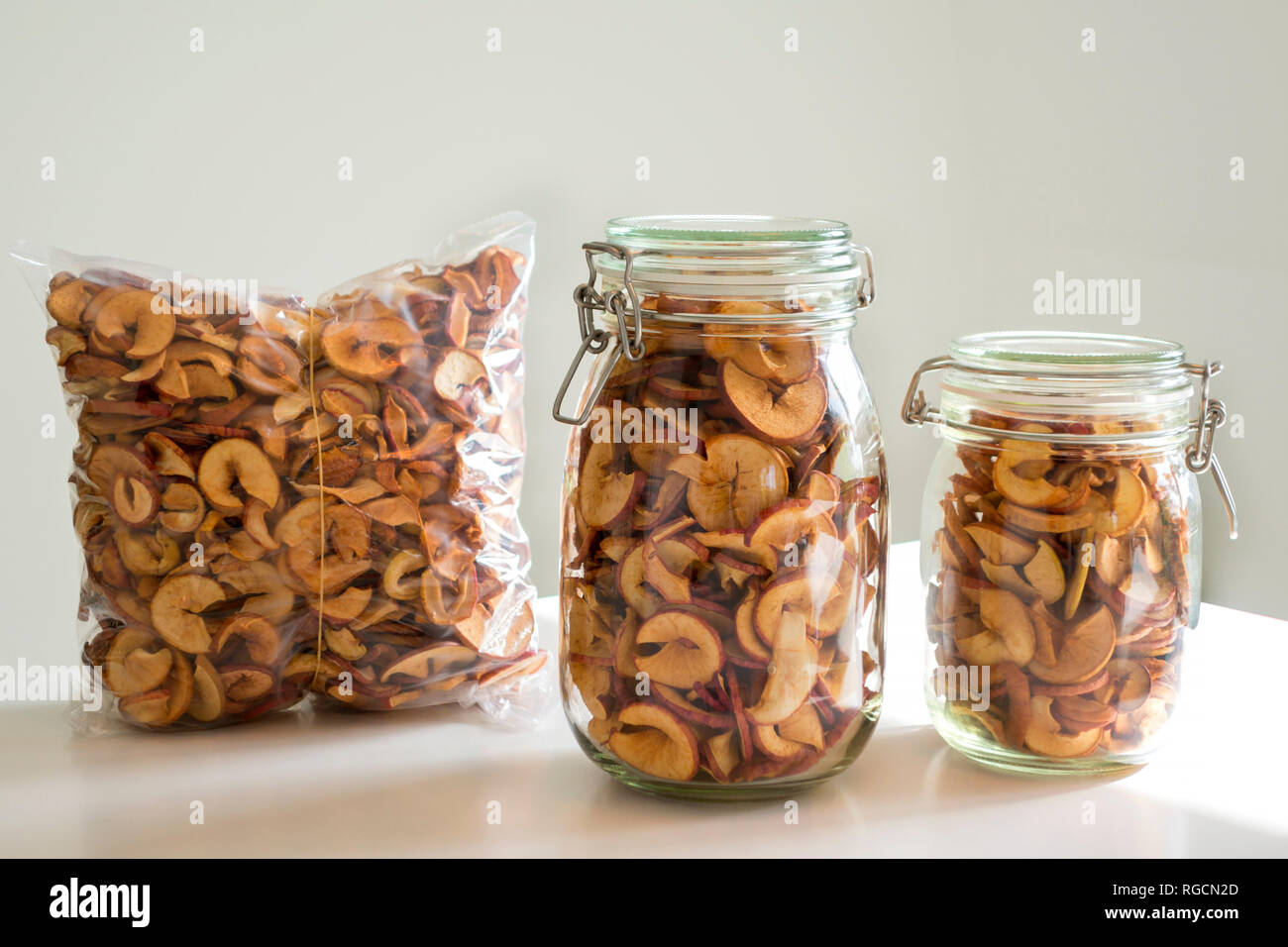 Due bicchieri e una confezionati sotto vuoto il sacchetto in plastica di fatti in casa i chip Apple Foto Stock