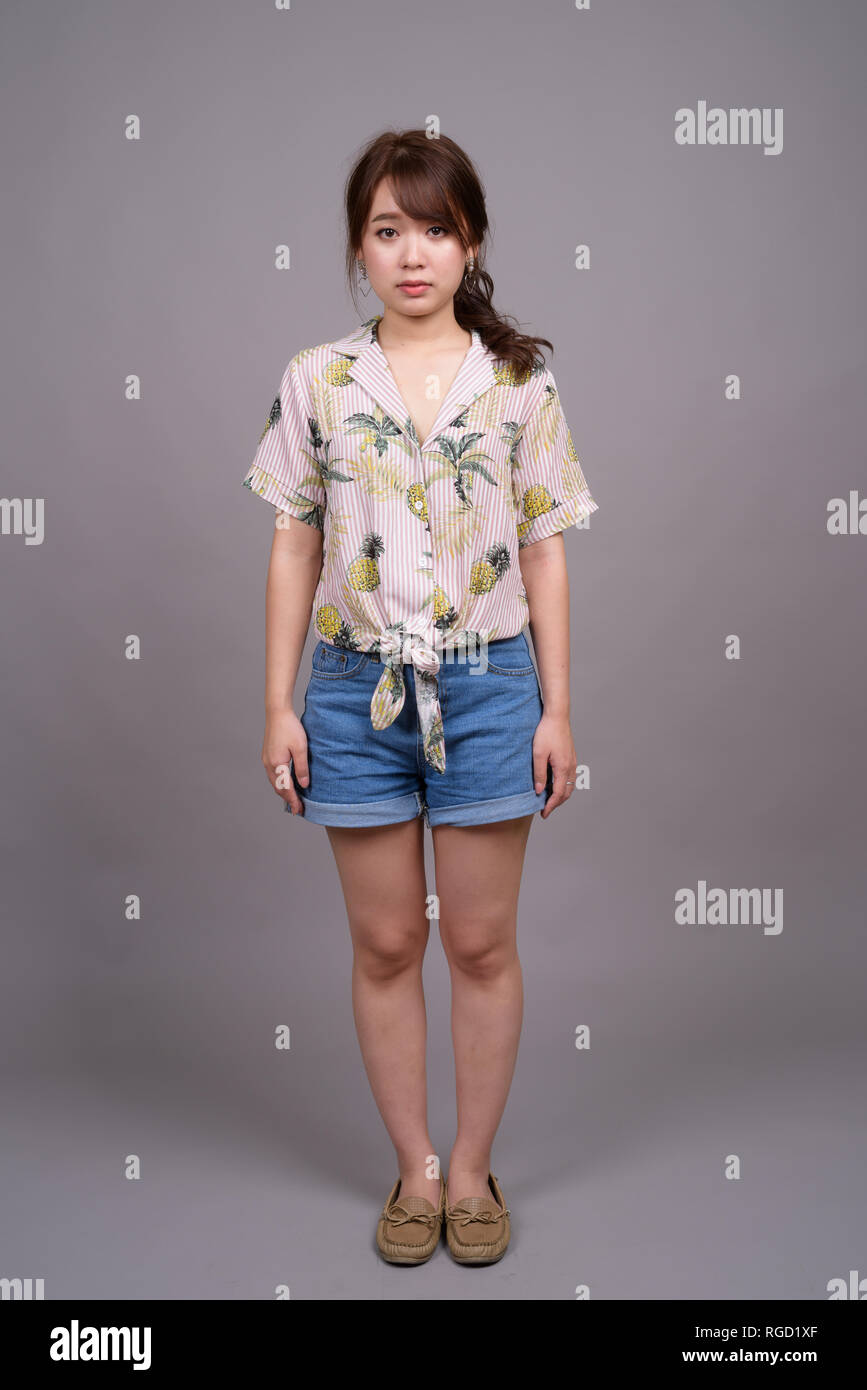 A piena lunghezza Ritratto di giovane e bella donna asiatica in piedi Foto Stock