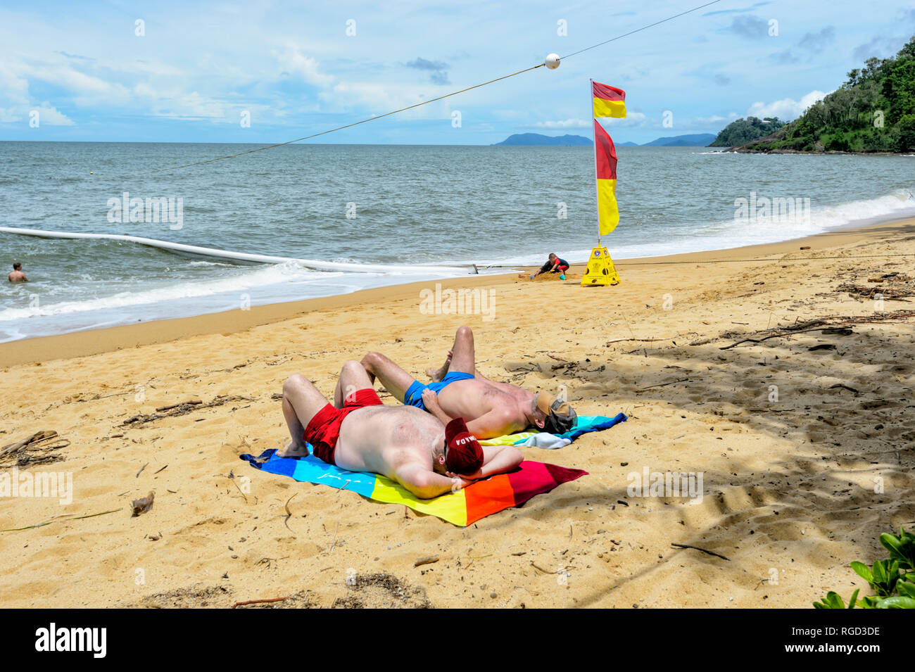 Due uomini a prendere il sole sulla spiaggia, Trinity Beach, Cairns Northern Beaches, estremo Nord Queensland, FNQ, QLD, Australia Foto Stock