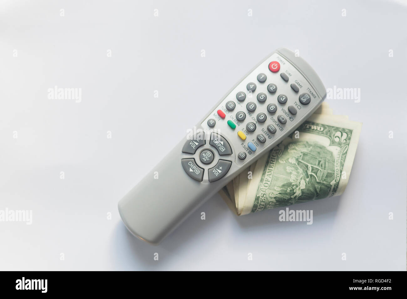 Telecomandi TV e dollari USA su sfondo bianco. Pay TV o il concetto di televisione. Foto Stock