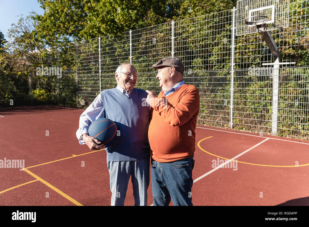 Montare due anziani divertirsi su un campo da basket Foto Stock