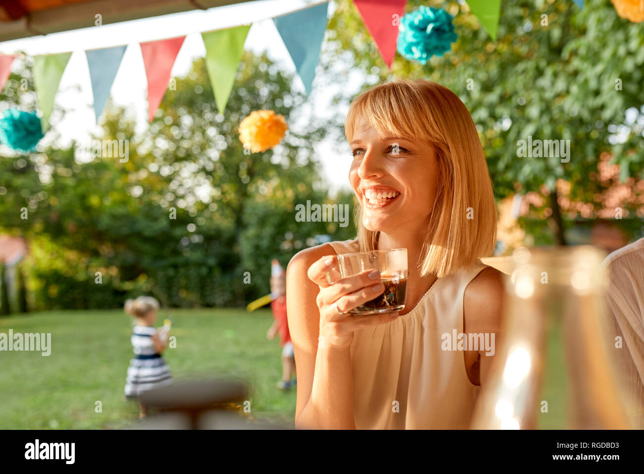 Donna felice di bere il caffè in un party in giardino Foto Stock