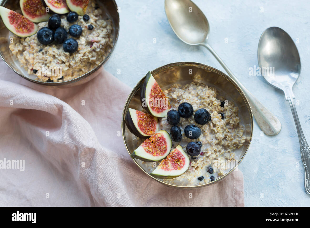 Bocce di porridge con spicchi di fichi, mirtilli e frutti di bosco essiccati Foto Stock