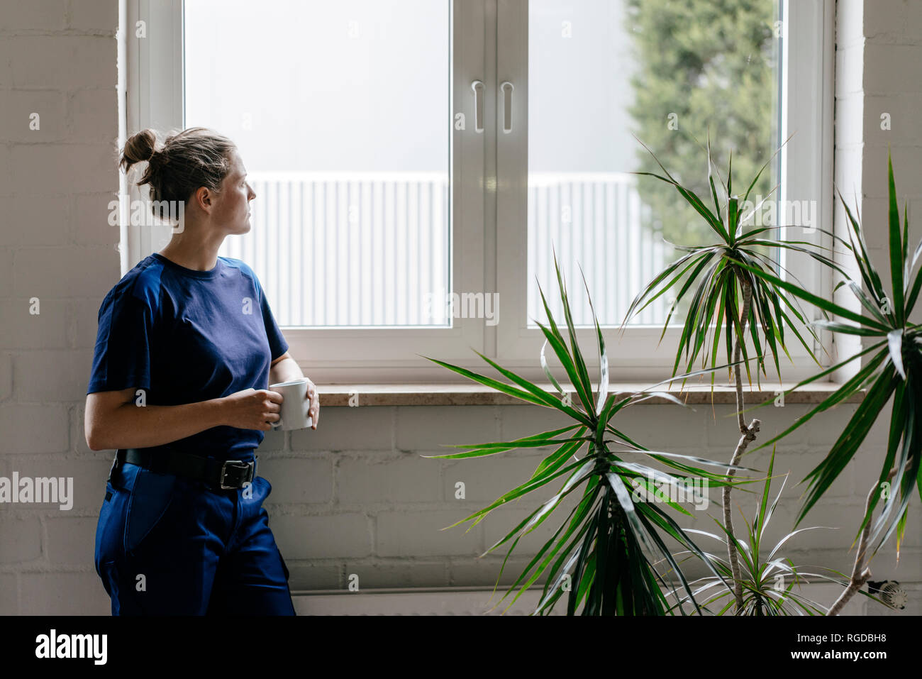 Giovane donna che lavorano in high tech enterprise, prendendo una pausa, bere caffè Foto Stock