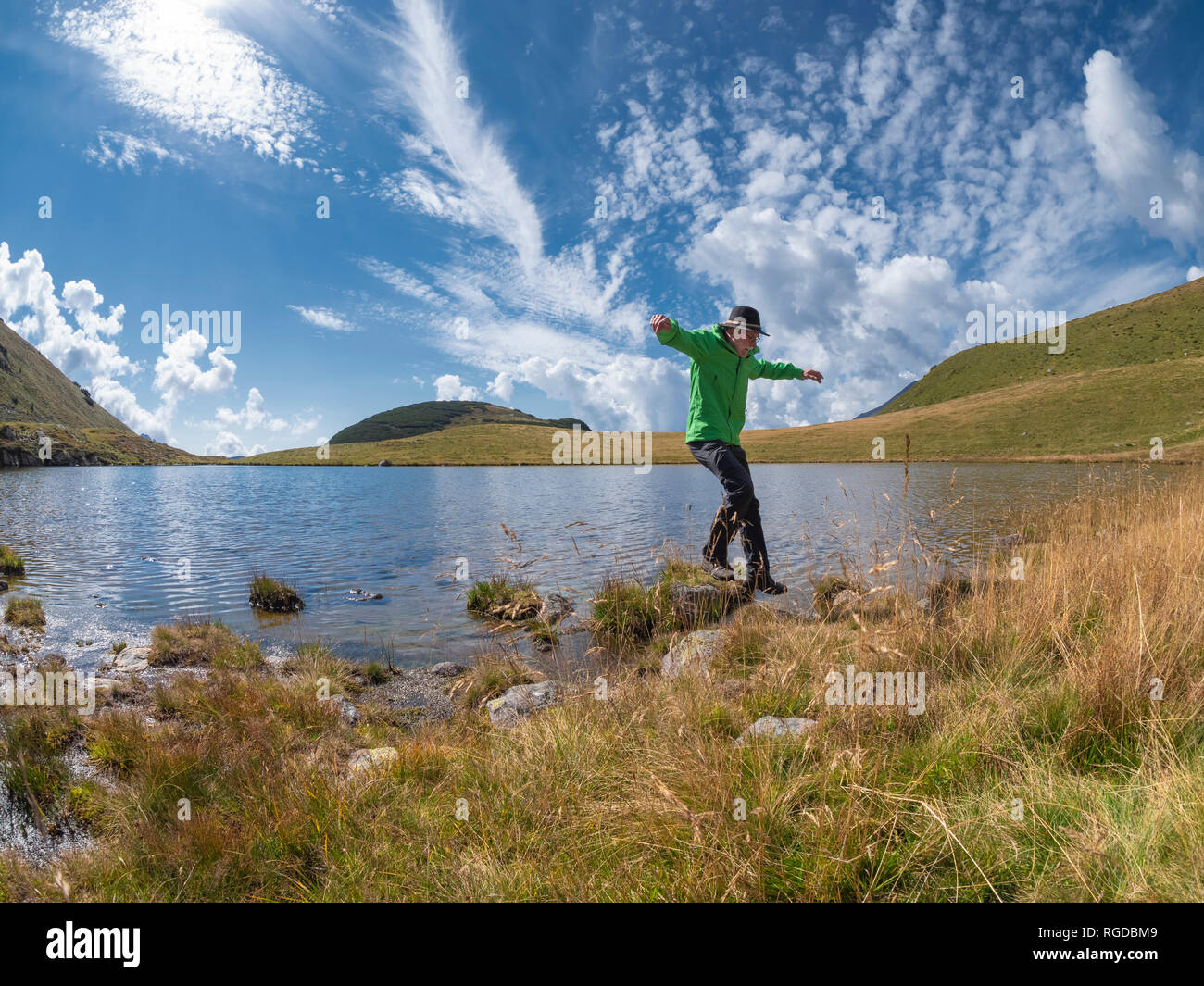 L'Italia, Lombardia, escursionista saltando al lago Foto Stock