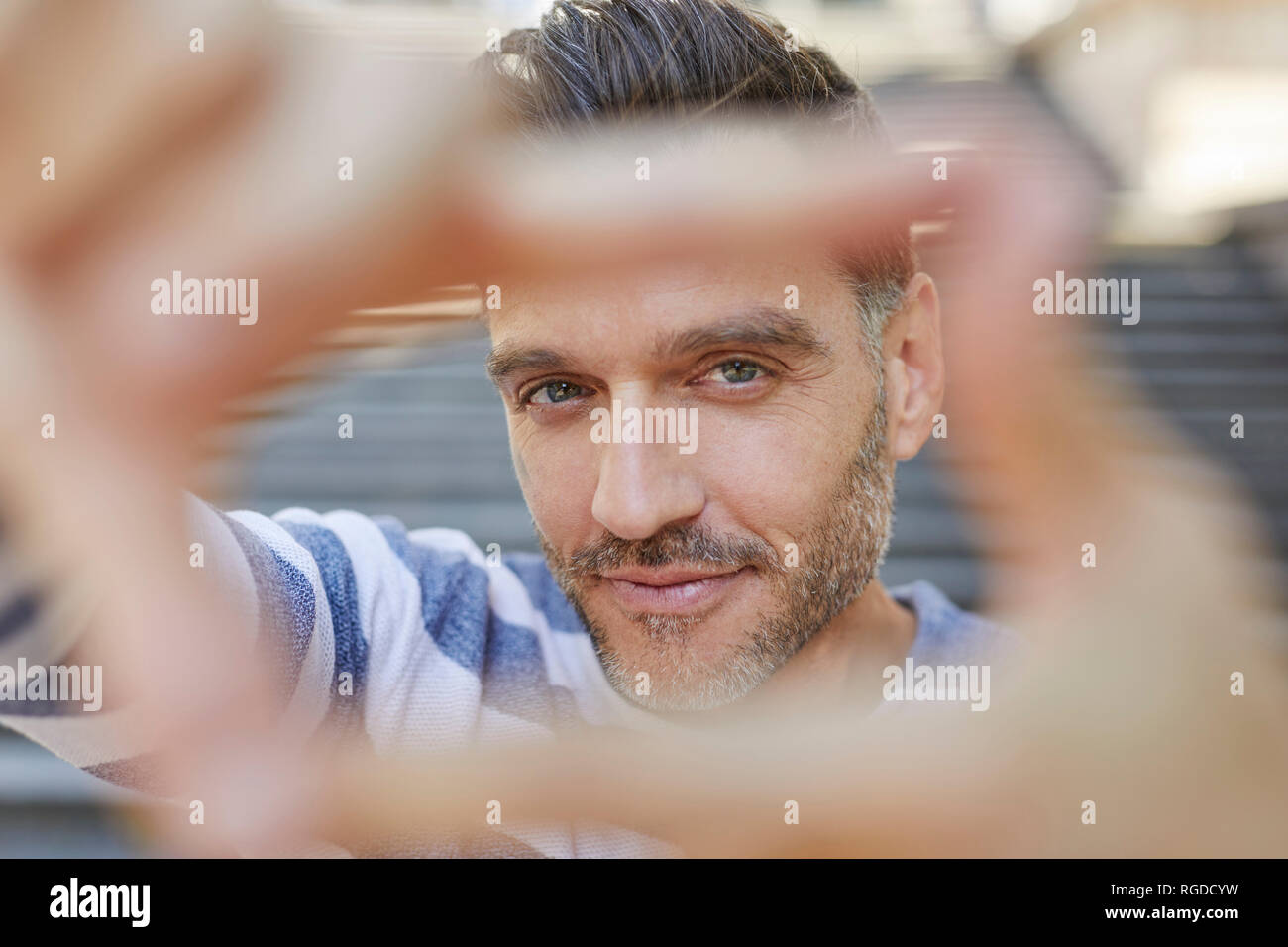 Ritratto di uomo maturo la costruzione di telaio con le sue dita Foto Stock