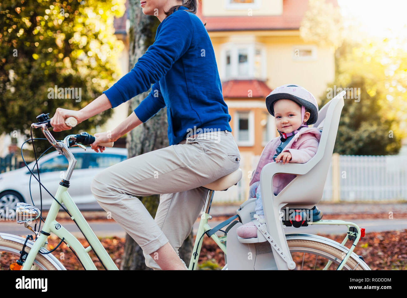 Madre e figlia Bicicletta Equitazione, baby indossando il casco in seduta i bambini del posto di guida Foto Stock