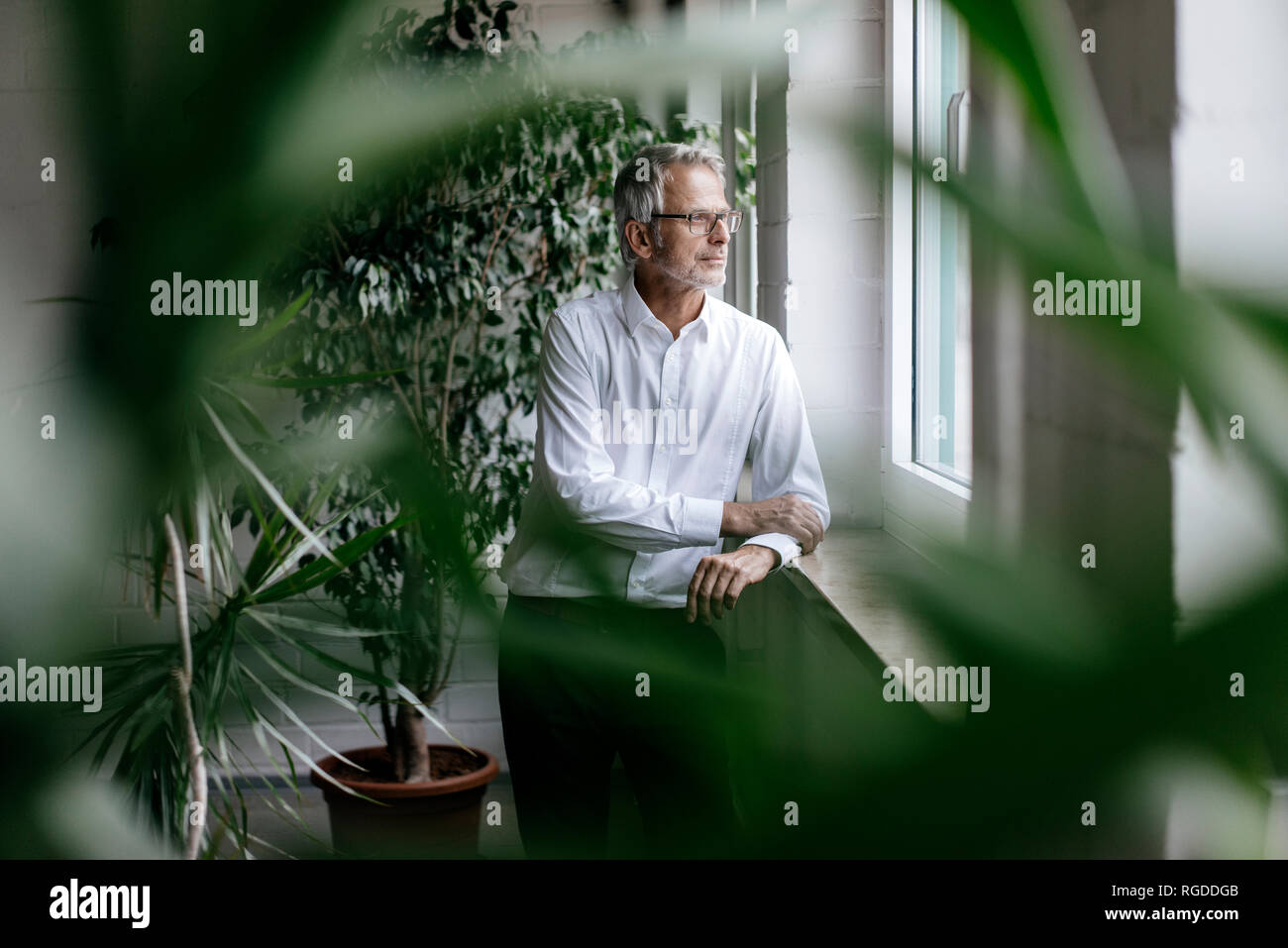 Imprenditore prendendo una pausa, guardando fuori della finestra Foto Stock