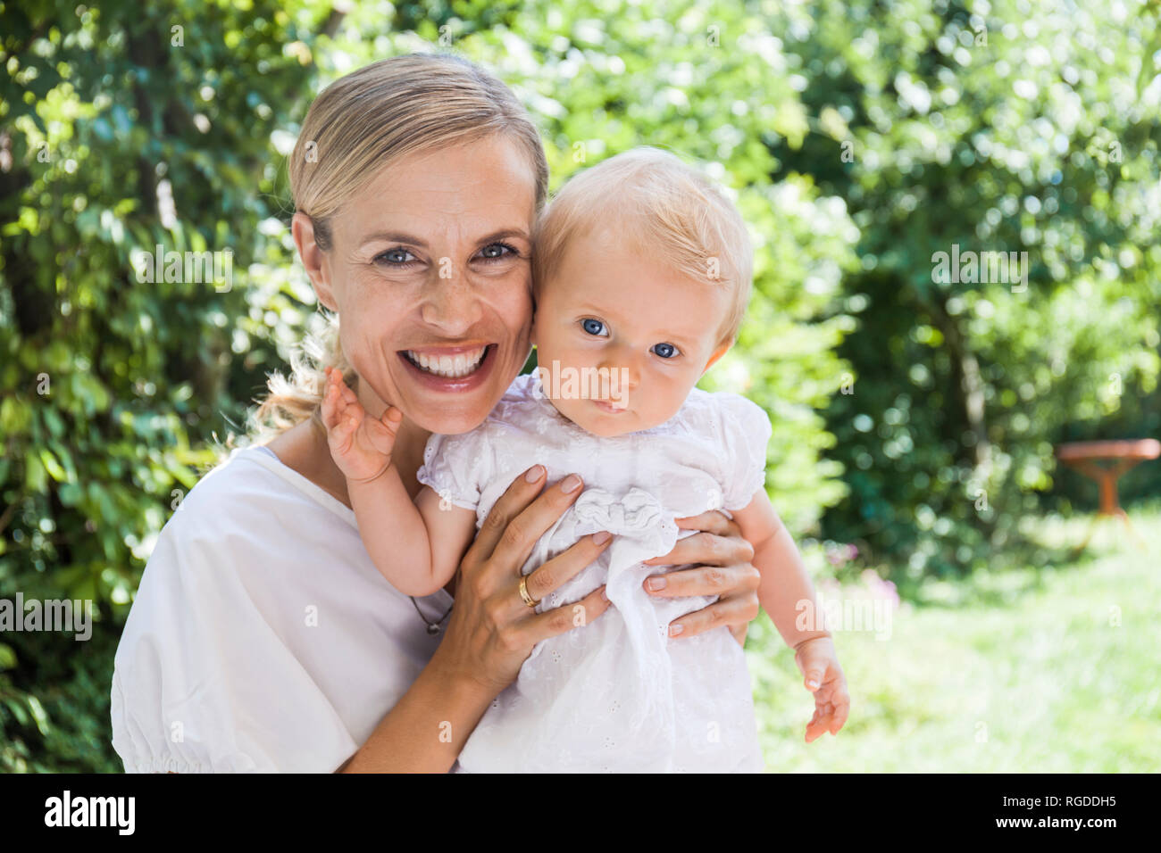 Ritratto di felice madre tenendo la sua bambina all'aperto Foto Stock