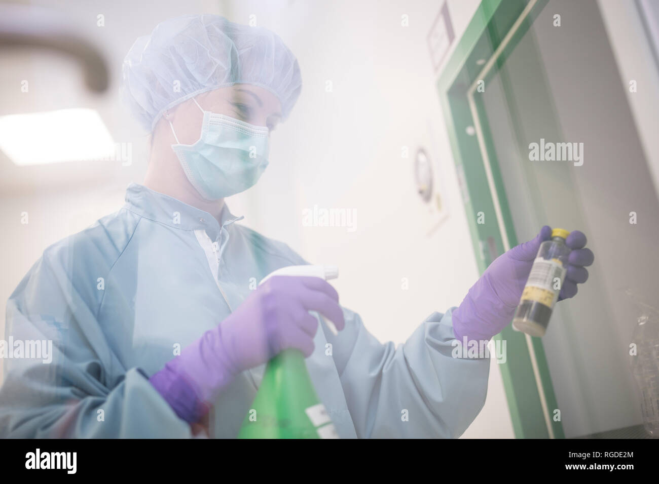 Tecnico di laboratorio tenendo la bottiglia e la bottiglia spray in laboratorio Foto Stock