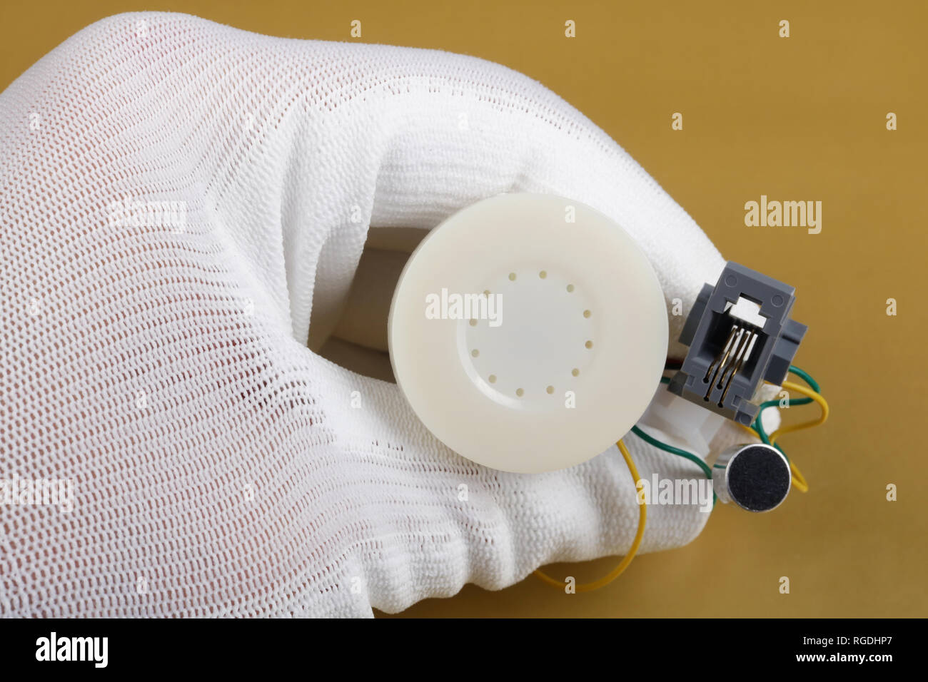 Il tecnico controlla la qualità di un altoparlante mini un microfono per telefono. La produzione di massa. La tecnologia moderna concezione macro. Foto Stock