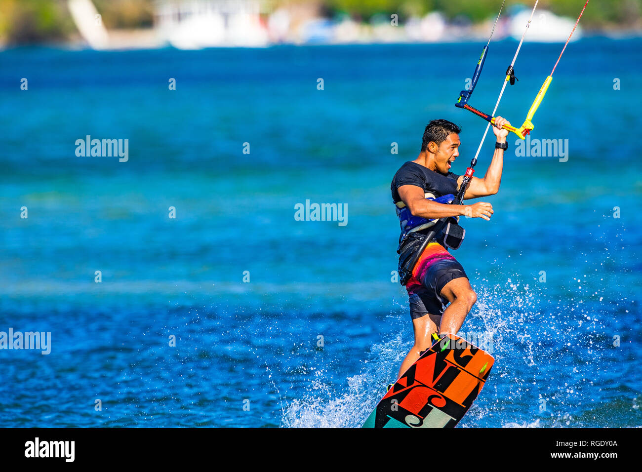 Kitesurfer sulla Costa del Sole tira fuori alcune mosse acrobatiche sulle acque blu turchese nel Queensland, Australia Foto Stock