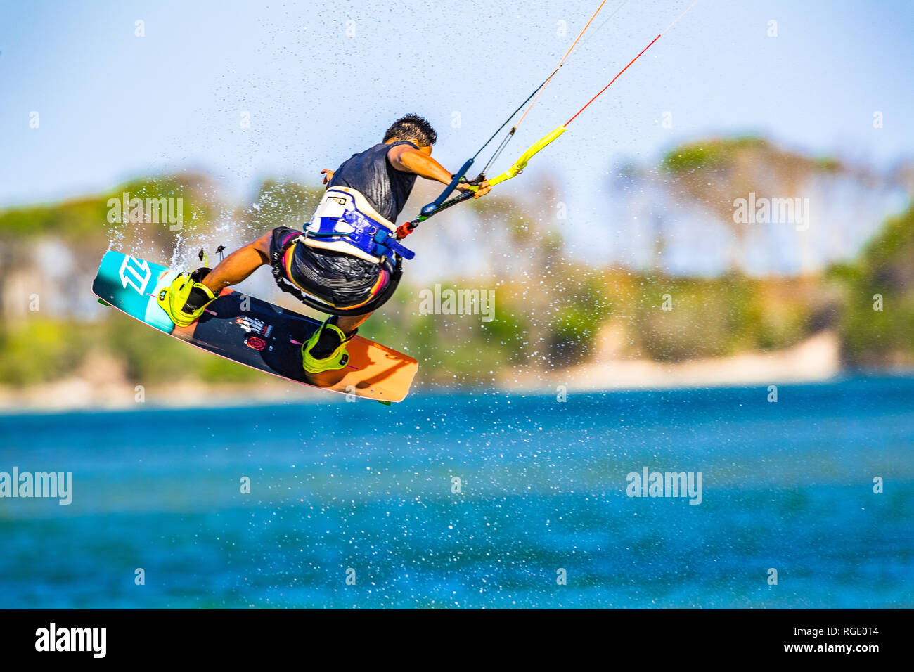 Kitesurfer sulla Costa del Sole tira fuori alcune mosse acrobatiche sulle acque blu turchese nel Queensland, Australia Foto Stock