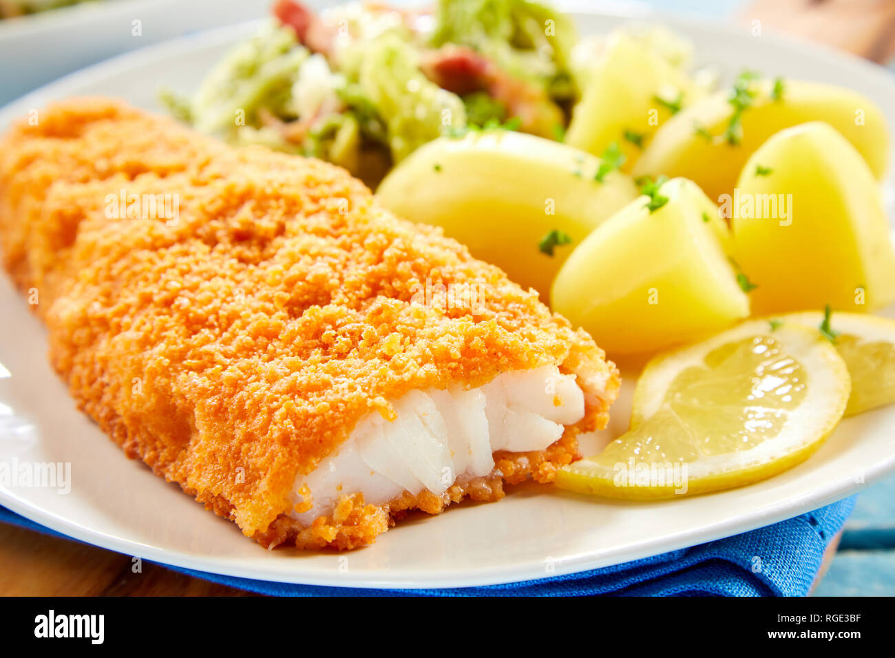 Vista ravvicinata di panato croccante di pesce servite sulla piastra con patate Foto Stock