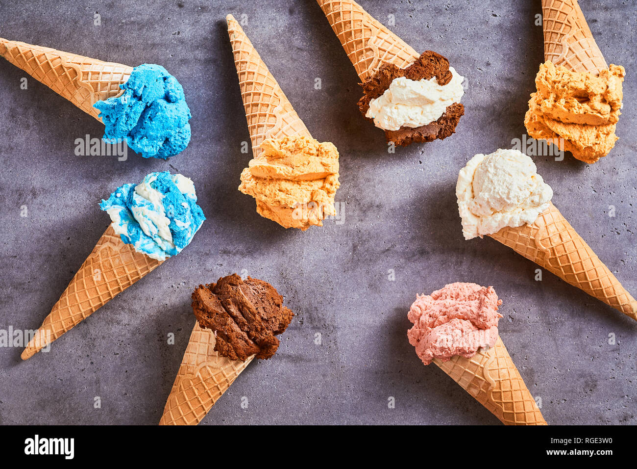 Deliziose specialità coni gelato con una varietà di sapori diversi disposti come una vita ancora su un grigio Sfondo ardesia Foto Stock