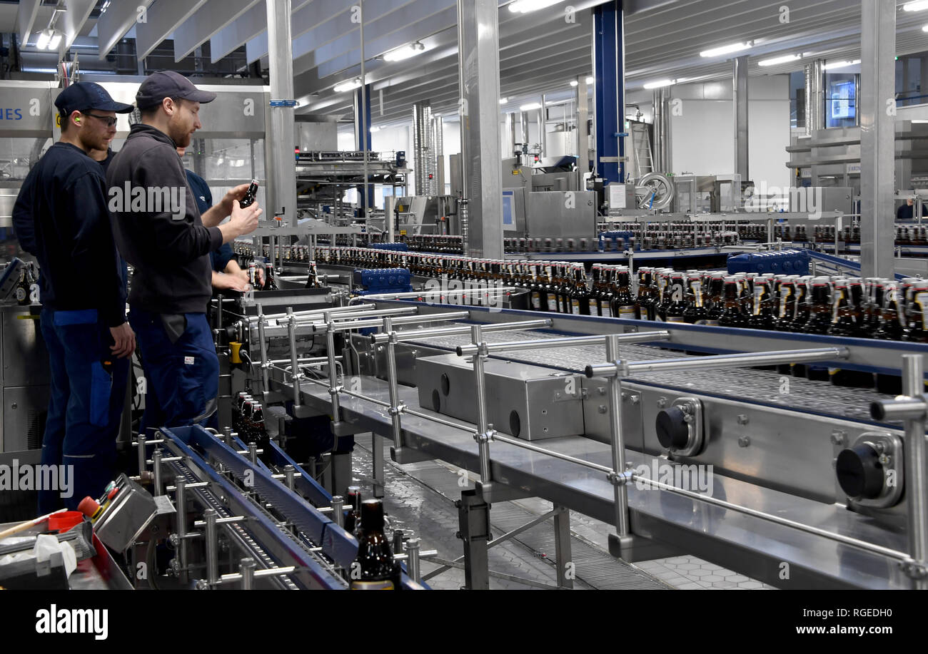 Flensburg, Germania. 28 gen, 2019. Bottiglie di birra correre lungo un nastro trasportatore nell'impianto di imbottigliamento della birreria di Flensburg. Alla conferenza stampa annuale su 31.01.2019, la birreria informerà circa il risultato dei business e sviluppo. Credito: Carsten Rehder/dpa/Alamy Live News Foto Stock