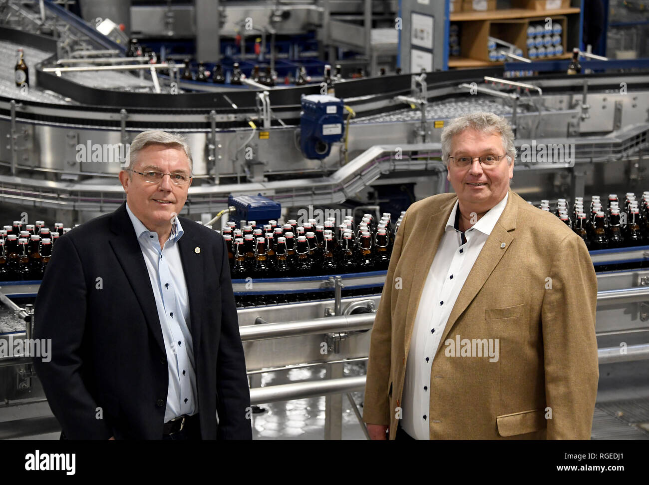 Flensburg, Germania. 28 gen, 2019. Hans-Peter Heyen (l-r) e Andreas Tembrockhaus, Managing Director di Flensburger birreria, sono in piedi in uno della birreria di linee di imbottigliamento. Alla conferenza stampa annuale su 31.01.2019, la birreria informerà circa il risultato dei business e sviluppo. Credito: Carsten Rehder/dpa/Alamy Live News Foto Stock