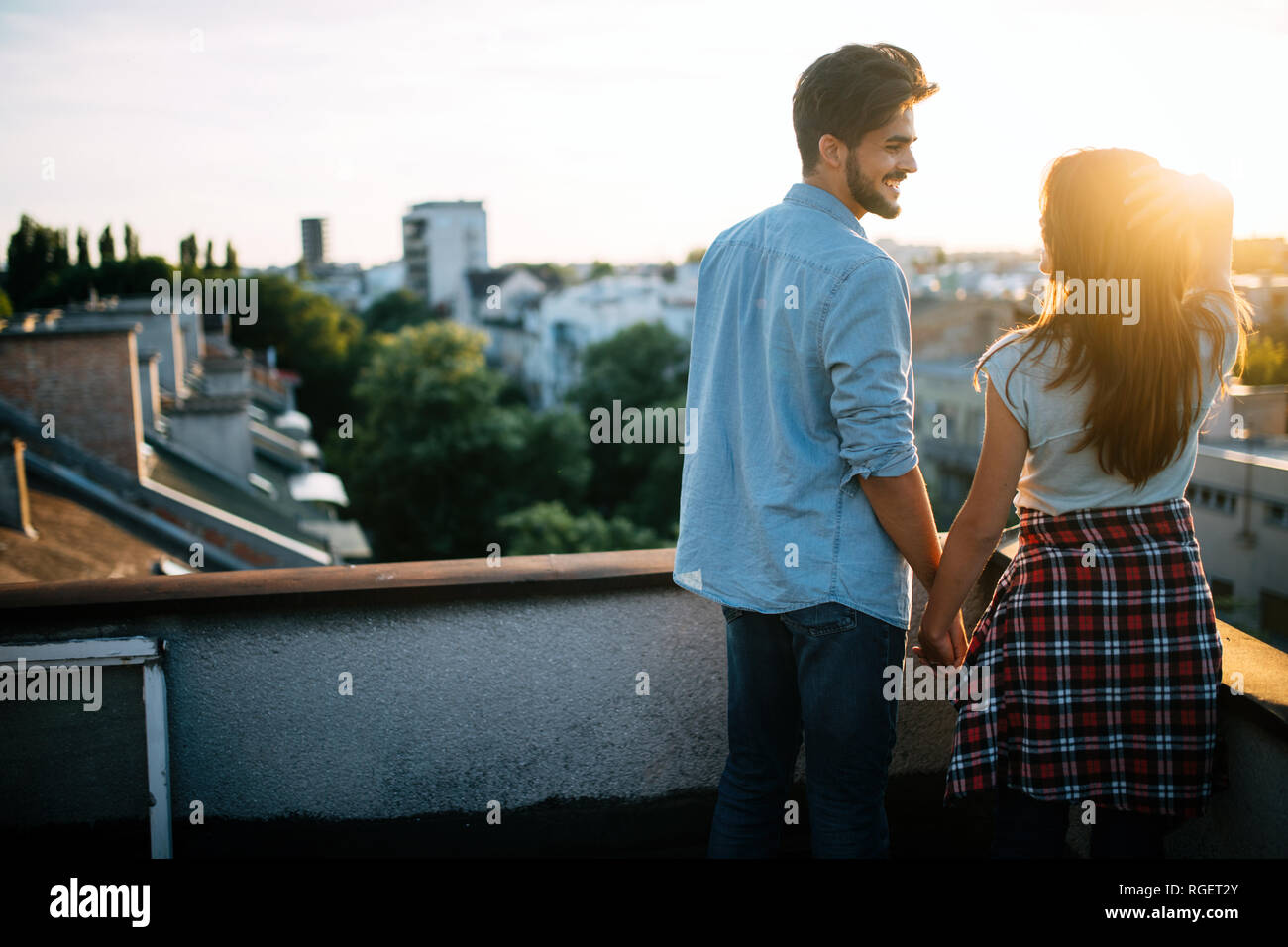 Matura in amore godendo nel tramonto in terrazza Foto Stock