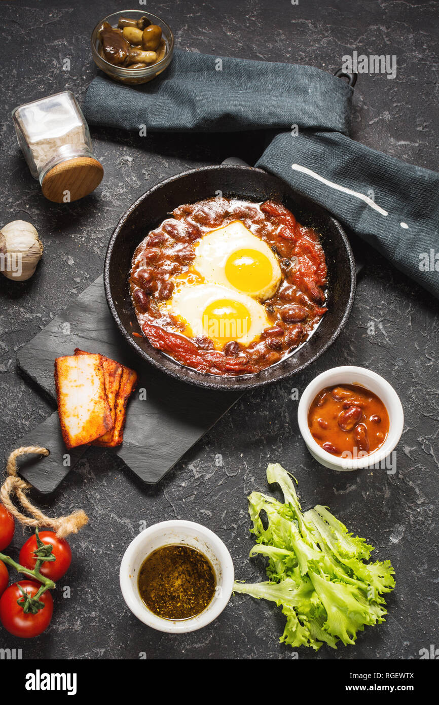 Shakshuka, uova fritte in salsa di pomodoro in ferro padella. Israele tipico cibo. Foto Stock