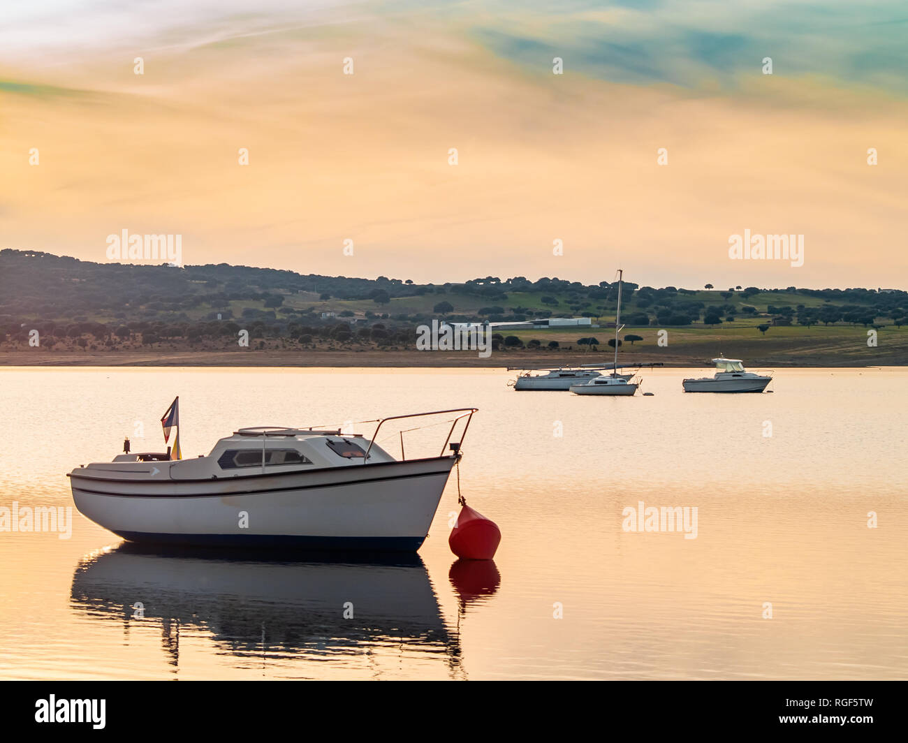 Barche sul lago al tramonto, ormeggiato con una boa e calma acqua nel serbatoio di La Maya (Salamanca) Foto Stock