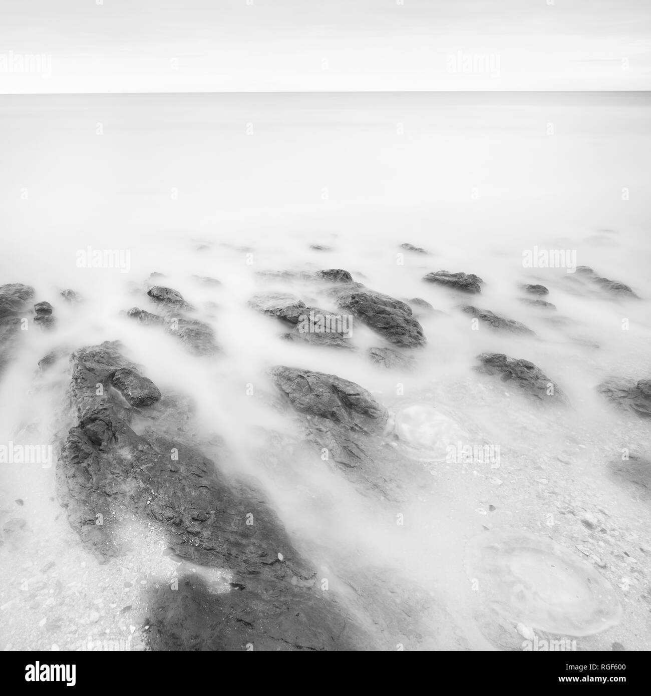 Lunga esposizione paesaggio artistico. Bianco nero Luce acqua e pietre prospettiva Foto Stock