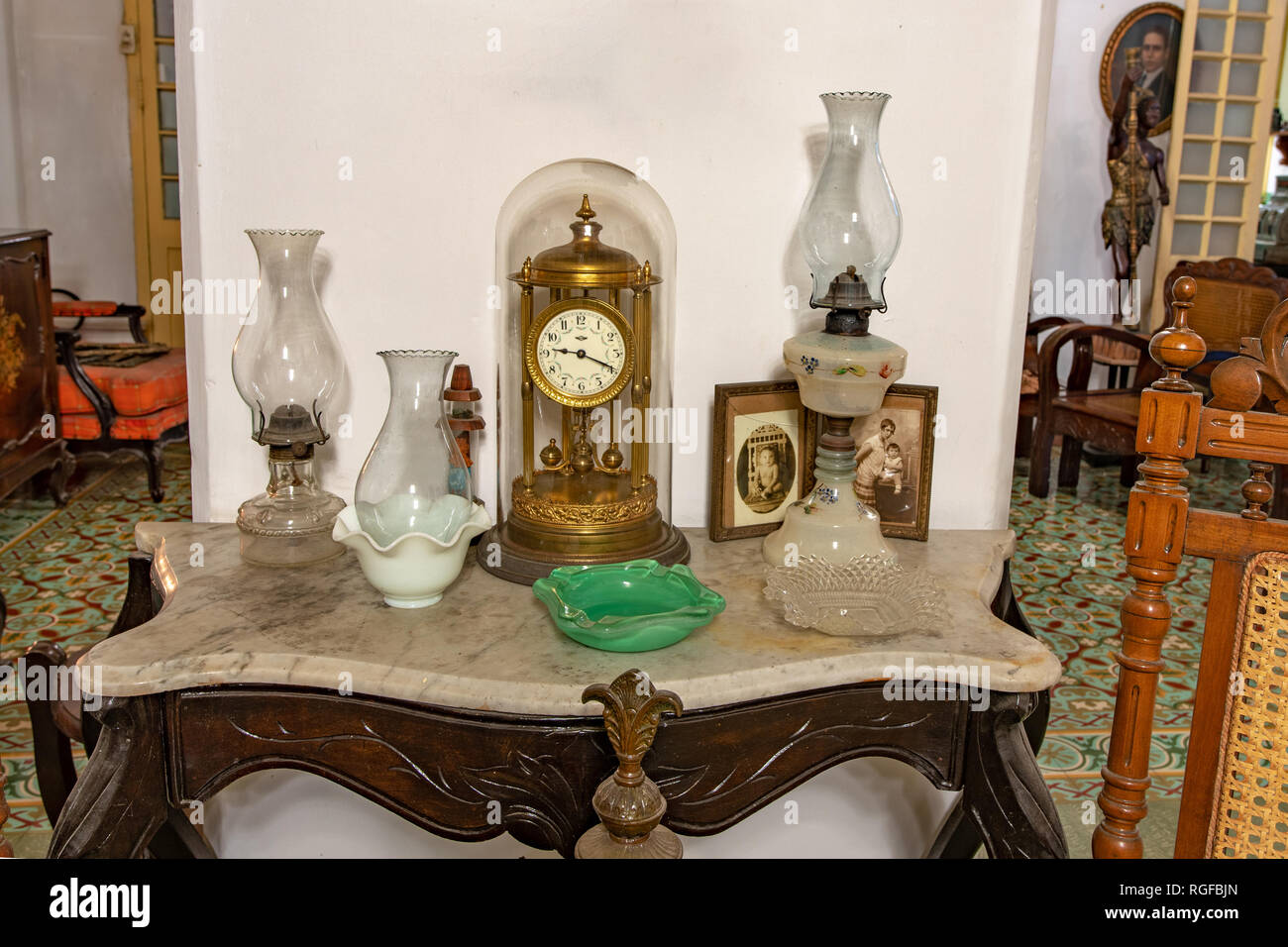 Orologio antico su un piccolo tavolo in una casa coloniale Foto Stock