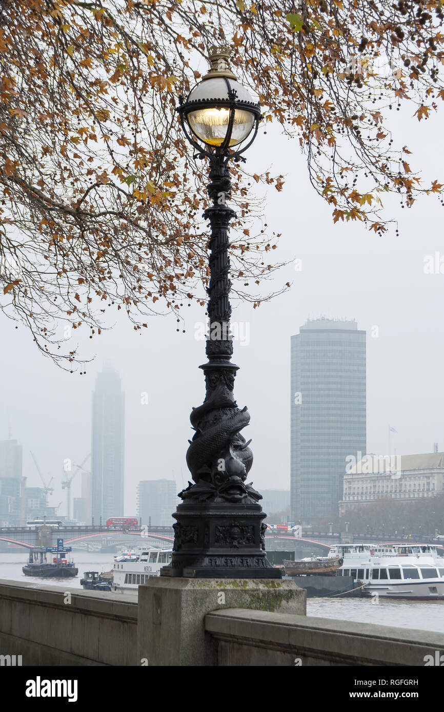 LONDON, Regno Unito - 23 novembre 2018: Foschia mattutina. Vista sul Tamigi e antiche lampione sul lungomare Foto Stock