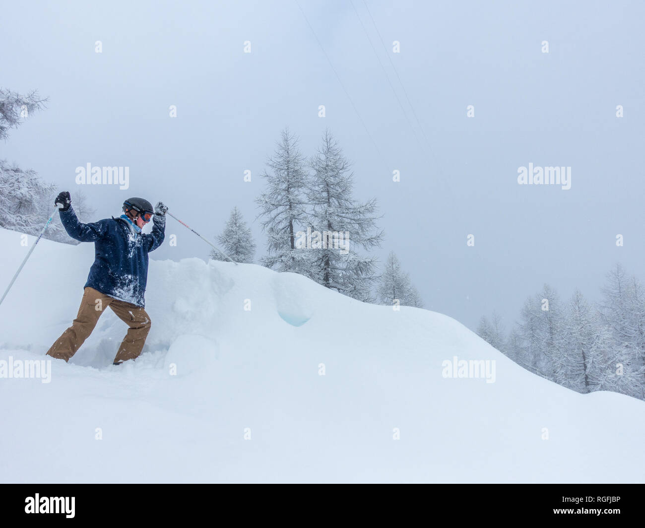 Un giovane sciatore divertendosi accoltellato neve con bastoncino da sci formazione sul pendio in Alpes Alpi Foto Stock