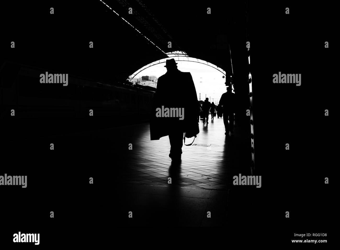 Silhouette di passeggeri in una stazione ferroviaria. Foto Stock